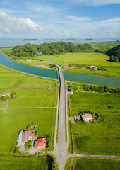 Breathtaking aerial drone view of waterway canal near green paddy crops land at Kampung Wai, Perlis, Malaysia