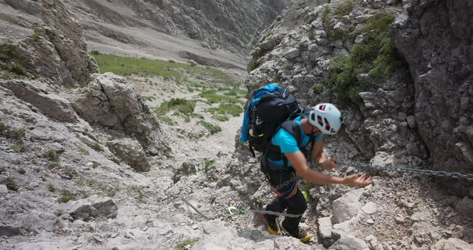 Man climbing on rocky mountain, passages with chains, summer, Grignetta, Italian Alps