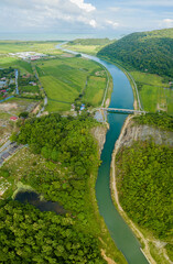 Breathtaking aerial drone view of waterway canal near green paddy crops land at Kampung Wai, Perlis, Malaysia