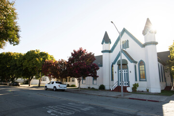 Afternoon sun shines on a historic church and city landscape of downtown Hollister, California, USA.