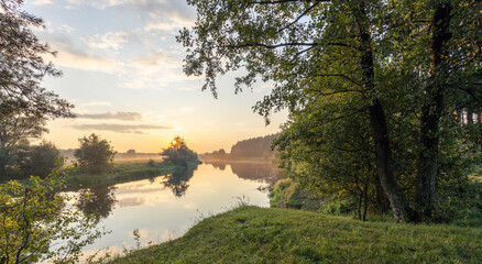 Beautiful sunset over a river with trees in the background
