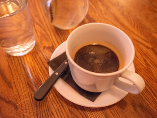 a cup of black coffee on the wooden table in the cafe in capital kyiv