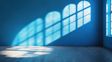 Obraz premium Minimalist blue wall backdrop highlighting sunlight shadows for product display in a serene and elegant environment.