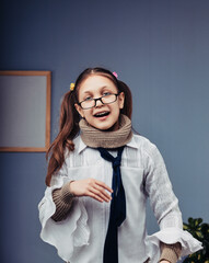 Smiling elementary age girl wearing eyeglasses and scarf