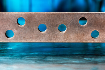 Copper grounding bar with holes on an industrial background, an element of an electrical...
