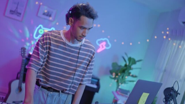 Asian young man artist DJ mixing and scratching music mixer controller. 