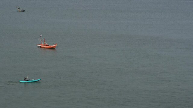 Men rowing boats at sea