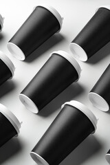 Multiple black takeaway coffee cups arranged in a repeating pattern on a white surface