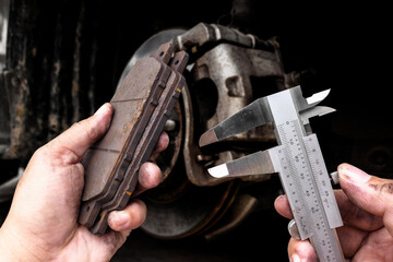 Precision measurement of brake pad with vernier caliper by auto mechanic , Car maintenance concept