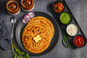 Aloo Paratha is a popular North Indian dish, especially in Punjab. It’s a flatbread stuffed with spiced mashed potatoes, served hot with tangy pickle (anchar) and flavorful chutney