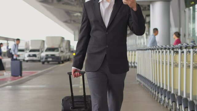 Asian businessman passenger walking in airport terminal to boarding gate. 