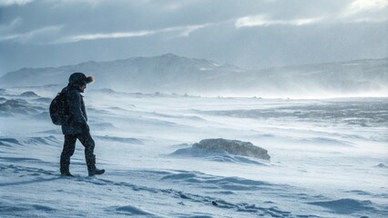 Solo hiker braving a snowy landscape in harsh weather