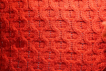 Close up of a red knit sweater with a pattern of circles