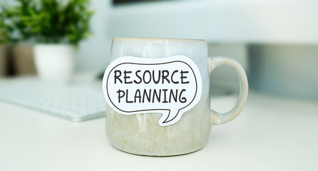 Resource Planning text on sticky note on mug standing on office desk