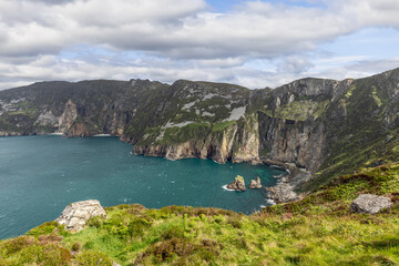 Obraz premium Slieve League cliffs in Ireland overlooking the Atlantic Ocean, showcasing rugged coastline, steep cliffs, and lush green landscape