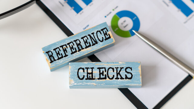 Reference Checks text on wooden block on office background