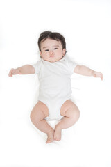 白いロンパースを着て仰向けに寝るカメラ目線の赤ちゃんを俯瞰撮影