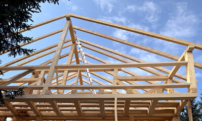 Part of unfinished house with wooden construction of roof. Small family house at construction.