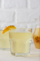 Pineapple kvass Tepache with cinnamon in a glasses on a light background. Fermented, probiotic drink. Vertical orientation.