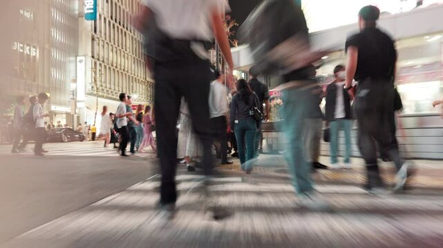 City, motion blur and people with rush for crossing road, safety perception and walking in street. Urban, legs and pedestrians in hurry for travel, commute and evening journey for tourists in Japan