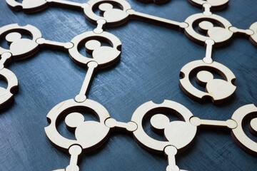 Close-up of a network of connected figurines. Teamwork and social connections.