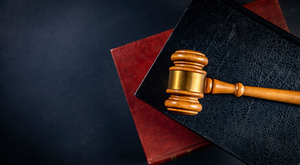 Judge gavel on a wooden desk, law books