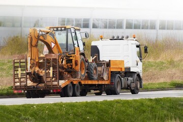 Excavator Transported by Flatbed Truck to Urban Construction Site