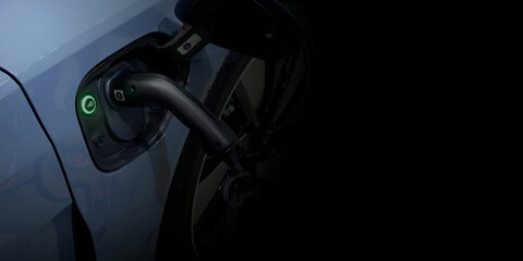 Close-up modern EV Car recharging battery from EV charging machine on black color background, EV Car are a popular new innovation and zero-emission vehicle, green energy for smart life, copy space