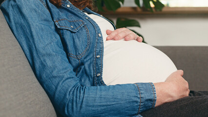 Expecting Mother Relaxing on Sofa in Denim Shirt Highlighting Pregnancy