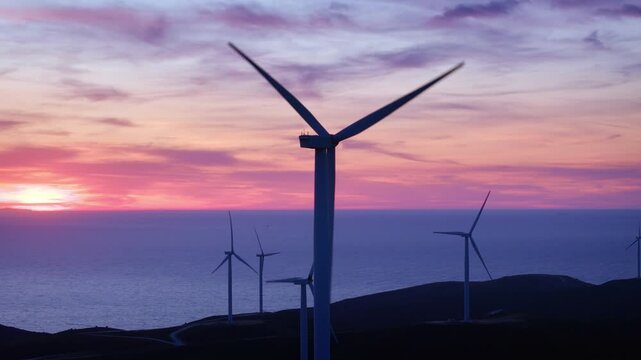 Wind turbines produce zero emission energy on colorful sunset, modern power plant, alternative energy sources