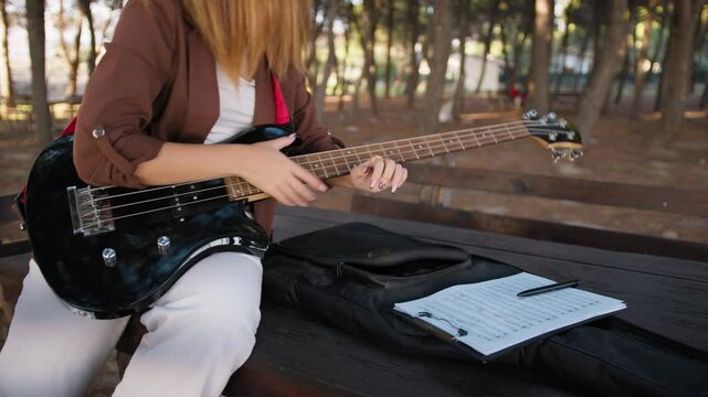 Girl Takes Sheet Music On Table With Bass Instrument In Nature