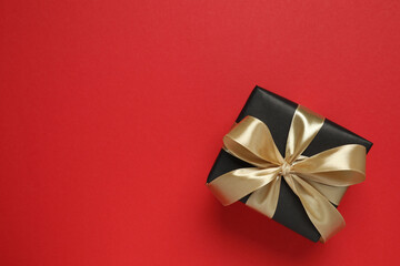 Beautiful gift box tied with bow on color background 