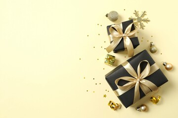 Beautiful gift boxes tied with bows and Christmas decorations on color background 