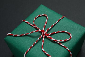 Beautiful gift box tied with bow on black background 