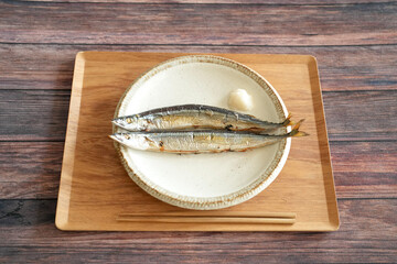 Two salt-grilled sauries, the most important autumn food for Japanese people, are served on a...