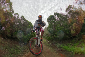 Naklejka premium Cyclist Riding the Bike on the Dirt Road.