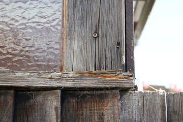 Rotting wooden window frame with splintered wood beside window