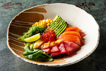 A vibrant poke bowl featuring fresh avocado, corn, sesame seeds, lime, and assorted sashimi on a bed of rice and greens, served in a ceramic dish. Perfect for healthy eating and food photography.