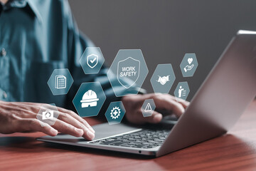 Work safety concept. Businessman use laptop with safety icons on virtual screen for working standard process and zero accidents. regulations and standard in industry.
