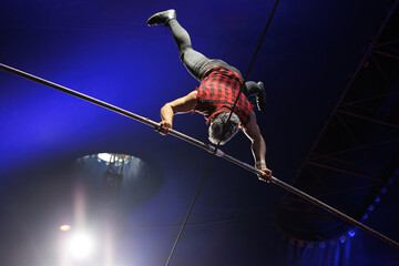 Circus show with tightrope walkers under dome of the circus under the light of spotlights and smoke. © Studio Peace