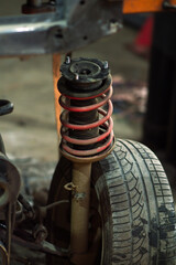 a mechanic disassembles an old dirty car engine on a red lift for repair and tuning