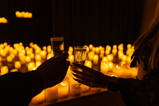 wine glasses on the background of symphonic orchestra on stage with lots of candles