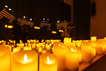 blurred symphonic orchestra on stage with lots of candles © Ruslan