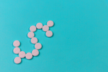 White round tablets on a blue background are folded into the shape of an American dollar.
