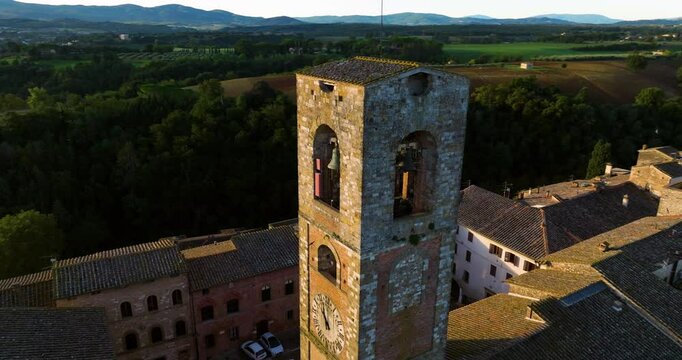 Medieval Cathedral Clock Tower And Bell Tower of Colle di Val d`Elsa At Sunrise In Tuscany, Italy. Aerial Orbiting Shot