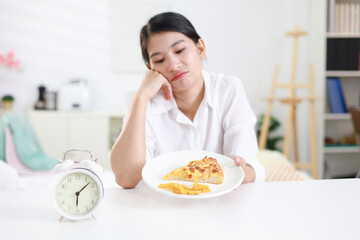 Weight loss concept. Girl refuses to eat pizza on a plate at home. Hand pushes away. Refuses junk food or fast food. Trying to not get fat. Healthy nutrition for weight loss.