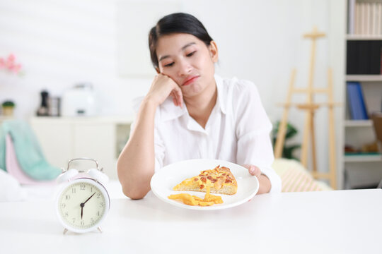 Weight loss concept. Girl refuses to eat pizza on a plate at home. Hand pushes away. Refuses junk food or fast food. Trying to not get fat. Healthy nutrition for weight loss.