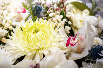 White bouquet of different flowers with a chrysanthemum flower in the center