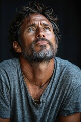 Fototapeta premium Pensive man gazing upward with thoughtful expression and rugged style