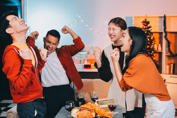 Group of young Asian man and women as friends having fun at a New Year's celebration, holding gift...